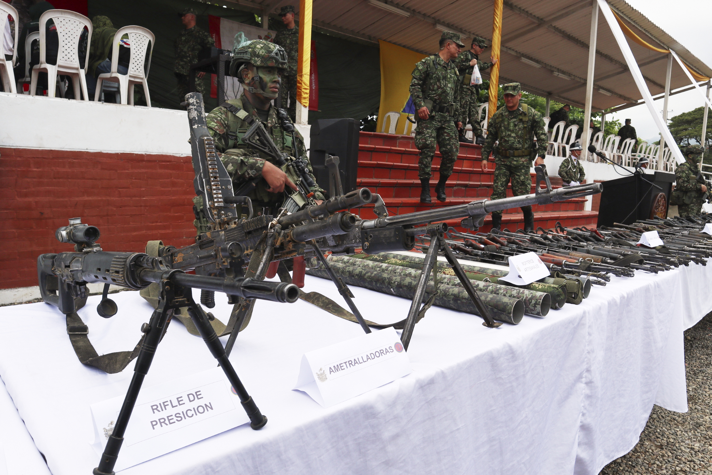 Soldiers guard weapons the military says was turned over by members of holdouts from the demobilized Revolutionary Armed Forces of Colombia (FARC), who retreated to the Army after being driven out of the Catatumbo region by National Liberation Army (ELN) rebels, in Cúcuta, Colombia, Saturday, Jan. 25, 2025.(AP Photo/Mario Caicedo)