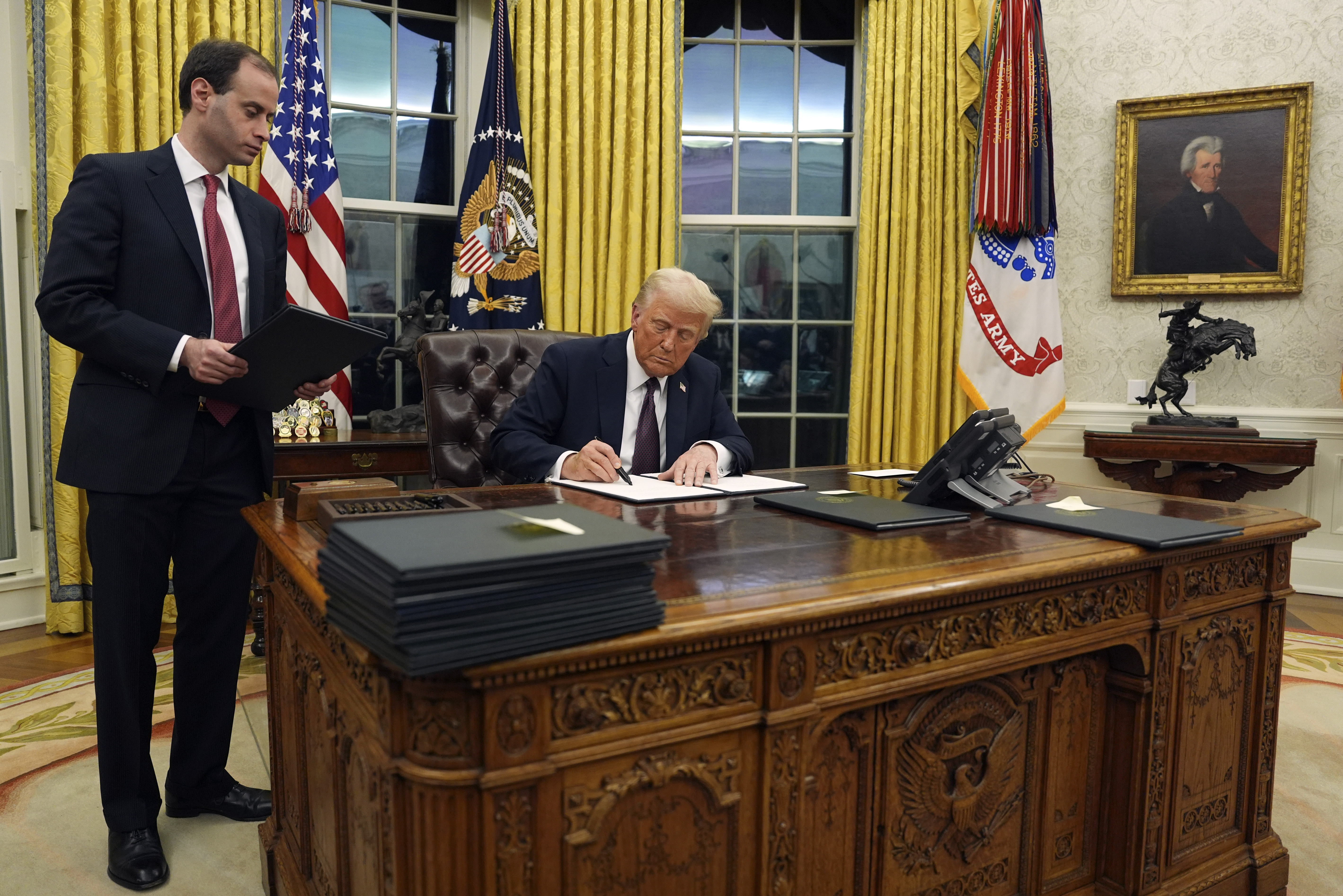 President Donald Trump signs an executive order withdrawing the U.S. from the World Health Organization in the Oval Office of the White House, Monday, Jan. 20, 2025, in Washington. (AP Photo/Evan Vucci)