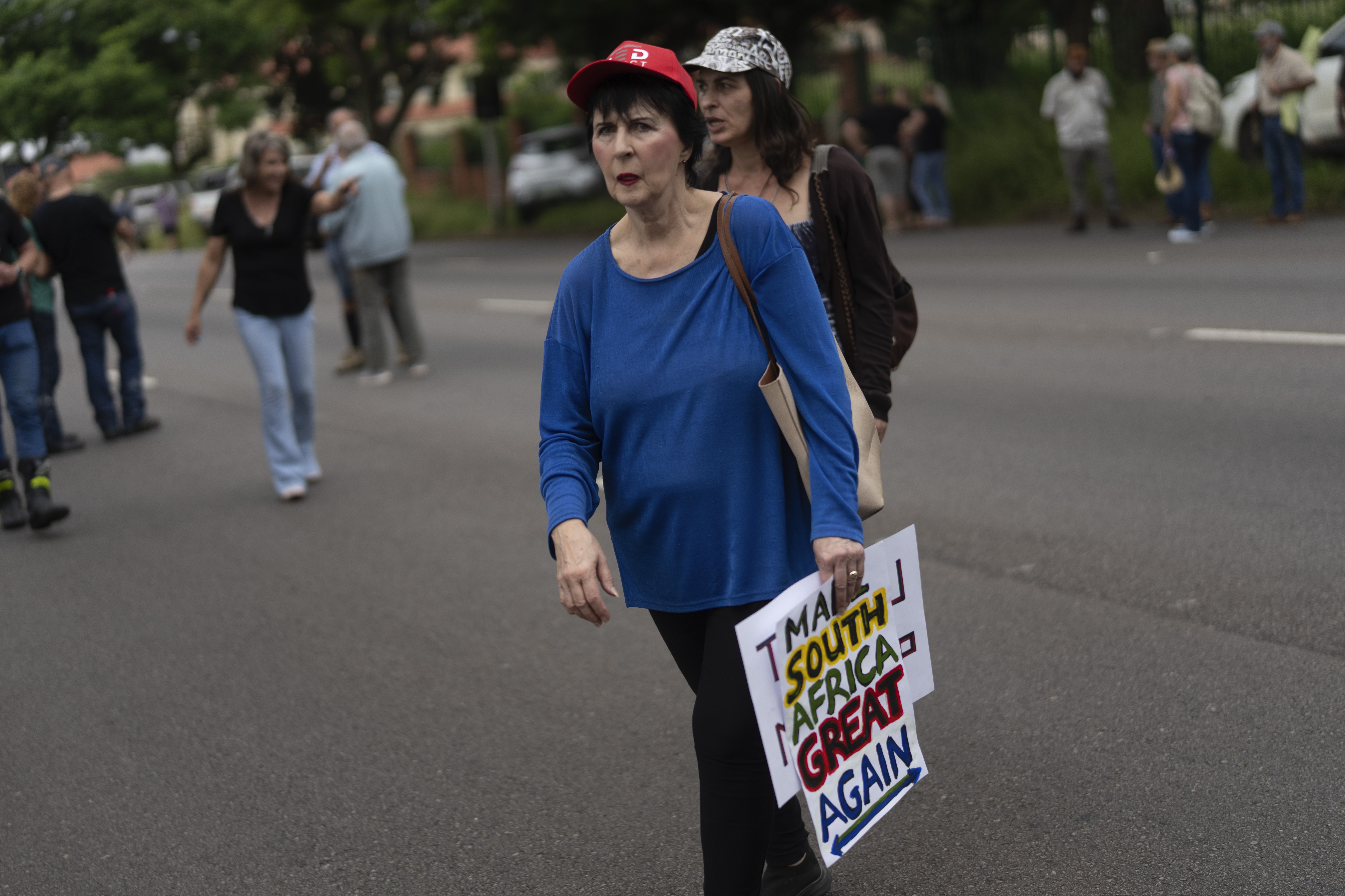 White South Africans demonstrate in support of U.S. President Donald Trump in front of the U.S. embassy in Pretoria, South Africa, Saturday, Feb. 15, 2025. (AP Photo/Jerome Delay)