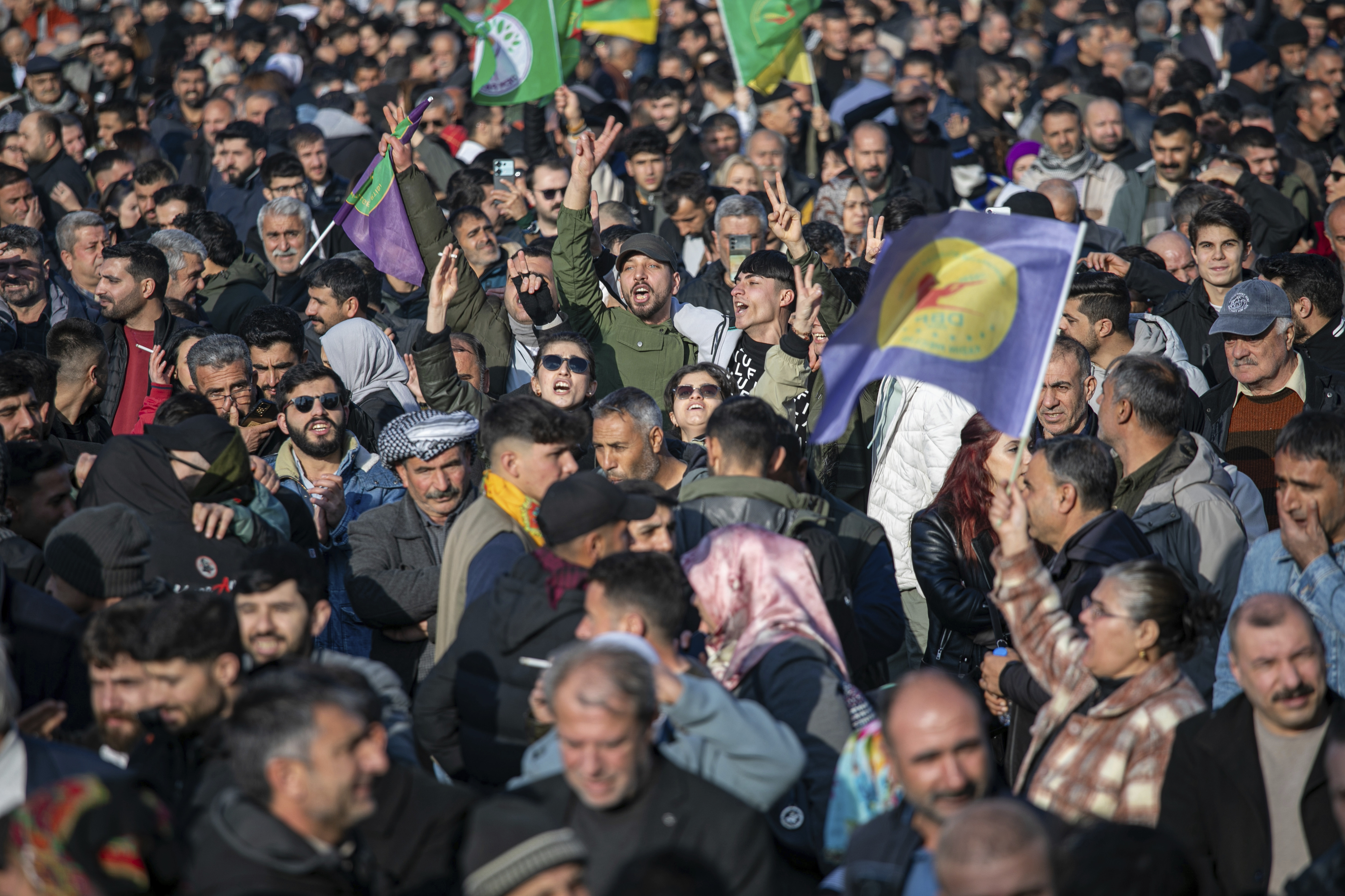 People gather to watch live on a tv screen a Pro-Kurdish Peoples' Equality and Democracy Party, or DEM, delegation members releasing an statement from the jailed leader of the rebel Kurdistan Workers' Party, or PKK, Abdullah Ocalan, in Diyarbakir, Turkey, Thursday, Feb. 27, 2025. (AP Photo/Metin Yoksu)